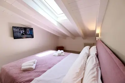 a bedroom with a bed with white sheets and a skylight at Ivi's House in Palermo