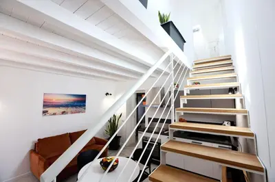 a white staircase in a home with a white ceiling at Ivi's House in Palermo