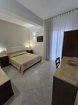 a bedroom with a bed and a table in it at Alle Porte di San Vito in San Vito lo Capo
