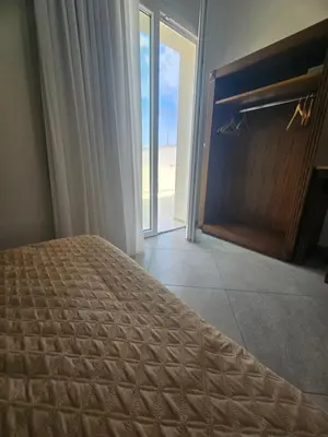 a bedroom with a bed and a fireplace with a view of the beach at Alle Porte di San Vito in San Vito lo Capo
