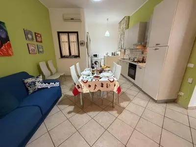 a living room with a table and a blue couch at Nuovo Basile by Holiday World in Palermo