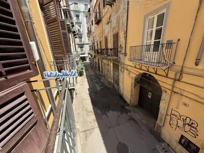 an empty alley in a city with buildings at Nuovo Basile by Holiday World in Palermo