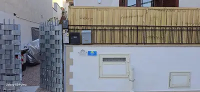 a white garage with a window and a wooden fence at la casetta di nin e gian mondello in Palermo