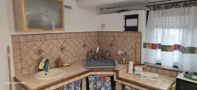 a tiled bathroom with a sink and a mirror at la casetta di nin e gian mondello in Palermo