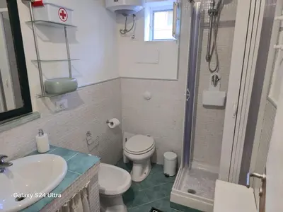 a bathroom with a toilet and a sink and a shower at la casetta di nin e gian mondello in Palermo