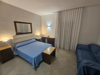a hotel room with a bed and a couch at Alle Porte di San Vito 2 in San Vito lo Capo