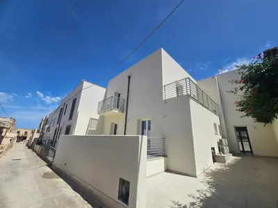 a white building with balconies on a street at Alle Porte di San Vito 2 in San Vito lo Capo