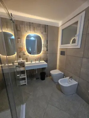 a bathroom with a sink and a toilet and a mirror at Alle Porte di San Vito 2 in San Vito lo Capo