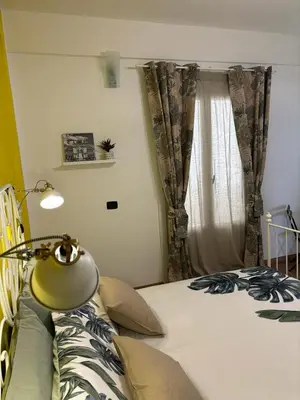 a bedroom with a bed with a lamp and a window at La Casetta Panoramica in Palermo