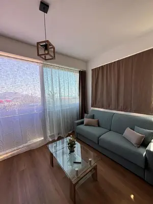 a living room with a blue couch and a glass table at La Casetta Panoramica in Palermo