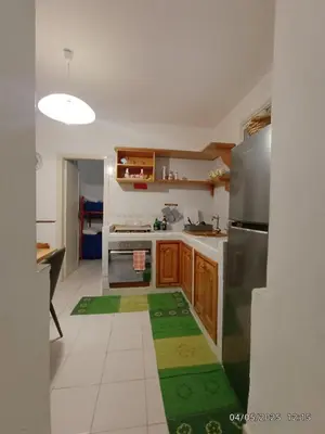 a kitchen with wooden cabinets and a stainless steel refrigerator at Villino Sirene Mondello in Palermo