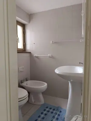 a white bathroom with a toilet and a sink at Villino Sirene Mondello in Palermo