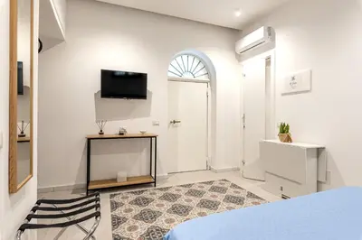a bedroom with a bed and a tv on the wall at Ai Vicoli Ciambra's Alley by Wonderful Italy in Monreale