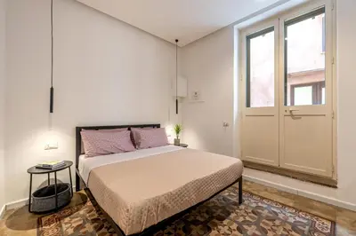 a bedroom with a bed and a large window at Ai Vicoli Ciambra's Alley by Wonderful Italy in Monreale