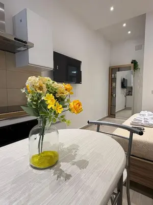 a vase filled with yellow flowers sitting on a table at LeRoccheRoom in Monreale