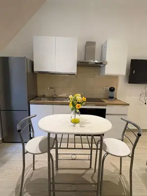a kitchen with a table with a vase of flowers on it at LeRoccheRoom in Monreale