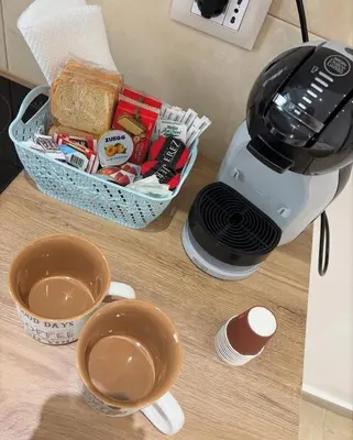 a coffee maker and two cups on a counter at LeRoccheRoom in Monreale