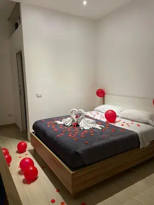 a bedroom with a bed with red balloons on the floor at LeRoccheRoom in Monreale