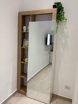 a wall with a mirror in a room with a tv at LeRoccheRoom in Monreale