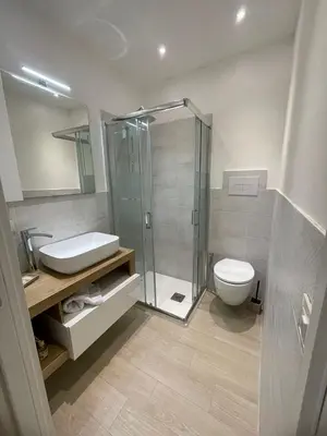 a bathroom with a shower and a toilet and a sink at LeRoccheRoom in Monreale