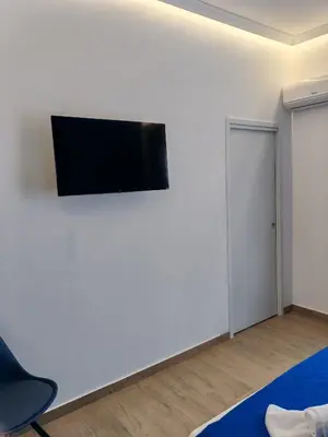 a living room with a flat screen tv on a white wall at MARE Suite in Palermo