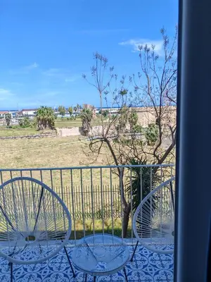 two chairs on a balcony with a view of a field at MARE Suite in Palermo