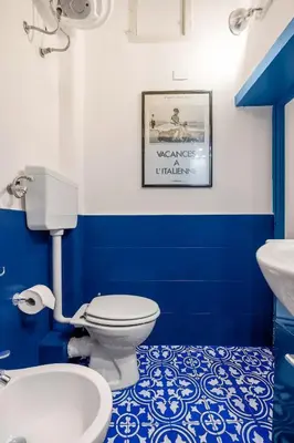 a blue and white bathroom with a toilet and a sink at Elegant Two-Room Apartment with Balcony & Suite in Palermo