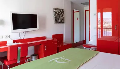 a living room with red furniture and a flat screen tv at Domina Zagarella multiproprietà MINIMO 6 NOTTI in Santa Flavia
