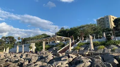 a group of chairs and umbrellas on a beach at Domina Zagarella multiproprietà MINIMO 6 NOTTI in Santa Flavia