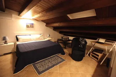 a bedroom with a bed in a room with wooden ceilings at Centro storico apartment & Loft - Amnesia Holiday Home in Palermo