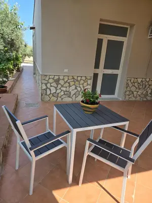 a wooden table and two chairs on a patio at Nonna Franca GuestHouse in Isola delle Femmine