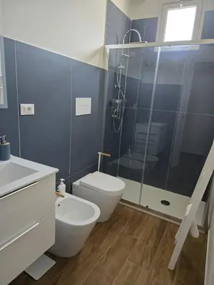 a bathroom with a toilet and a glass shower at Nonna Franca GuestHouse in Isola delle Femmine