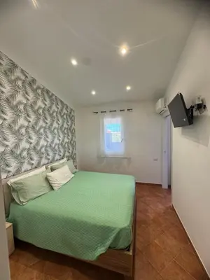 a bedroom with a green bed and a window at Dimora Solemar-Mareluna village in Campofelice di Roccella