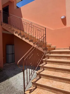 a staircase of a building with a metal railing at Dimora Solemar-Mareluna village in Campofelice di Roccella