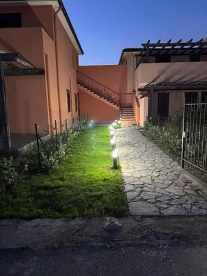 an alley between two buildings with lights on the grass at Dimora Solemar-Mareluna village in Campofelice di Roccella