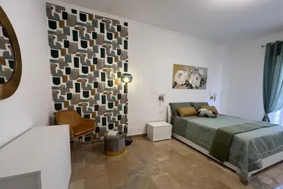 a bedroom with a bed and a chair at TramQuility House in Palermo