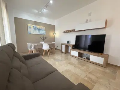 a living room with a couch and a flat screen tv at TramQuility House in Palermo
