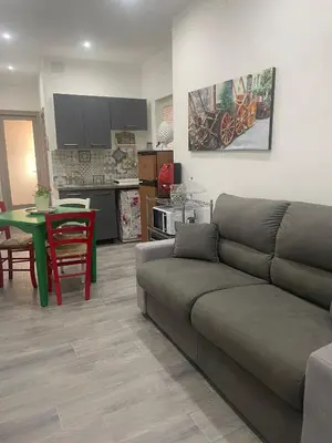 a living room with a couch and a kitchen at Altri tempi in Palermo