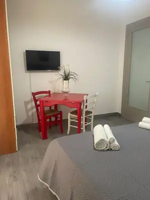 a room with a table and a red table and chairs at Altri tempi in Palermo