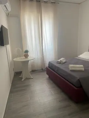 a bedroom with a bed and a white table at Altri tempi in Palermo