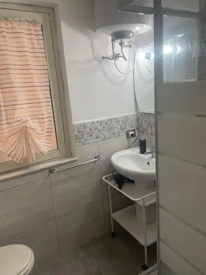 a bathroom with a sink and a toilet and a window at Altri tempi in Palermo