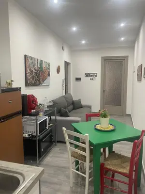 a living room with a green table and a couch at Altri tempi in Palermo