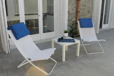 two white chairs and a table on a porch at Mondello Suites FLH - Riflessi in Palermo