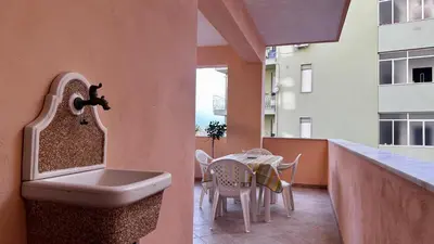 a bathroom with a sink and a table on a balcony at Albachiara Apartment vicino al mare di Capaci in Capaci