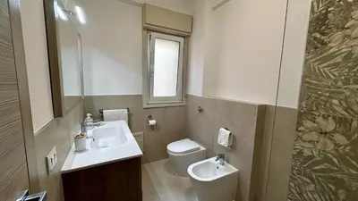 a bathroom with a sink and a toilet and a mirror at Albachiara Apartment vicino al mare di Capaci in Capaci