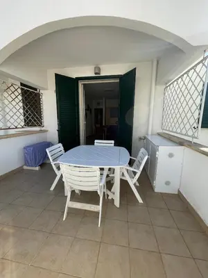 a white table and chairs on a balcony with a table and chairs at Le Palme House in Isola delle Femmine