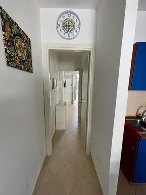 a hallway with a clock on the wall at Le Palme House in Isola delle Femmine