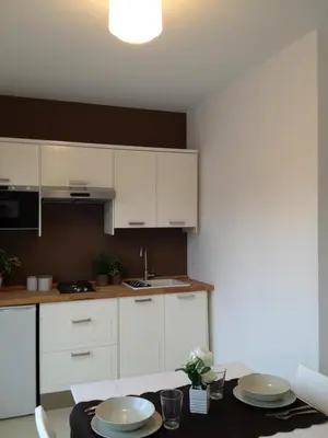 a kitchen with white cabinets and a table with plates on it at Mondello suites FLH - Posidonia in Palermo