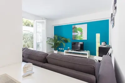 a living room with a brown couch and a blue wall at Mondello Suites FLH - Anemone in Palermo