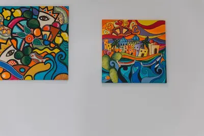 two pieces of art on a white wall at Serenello Home in Palermo
